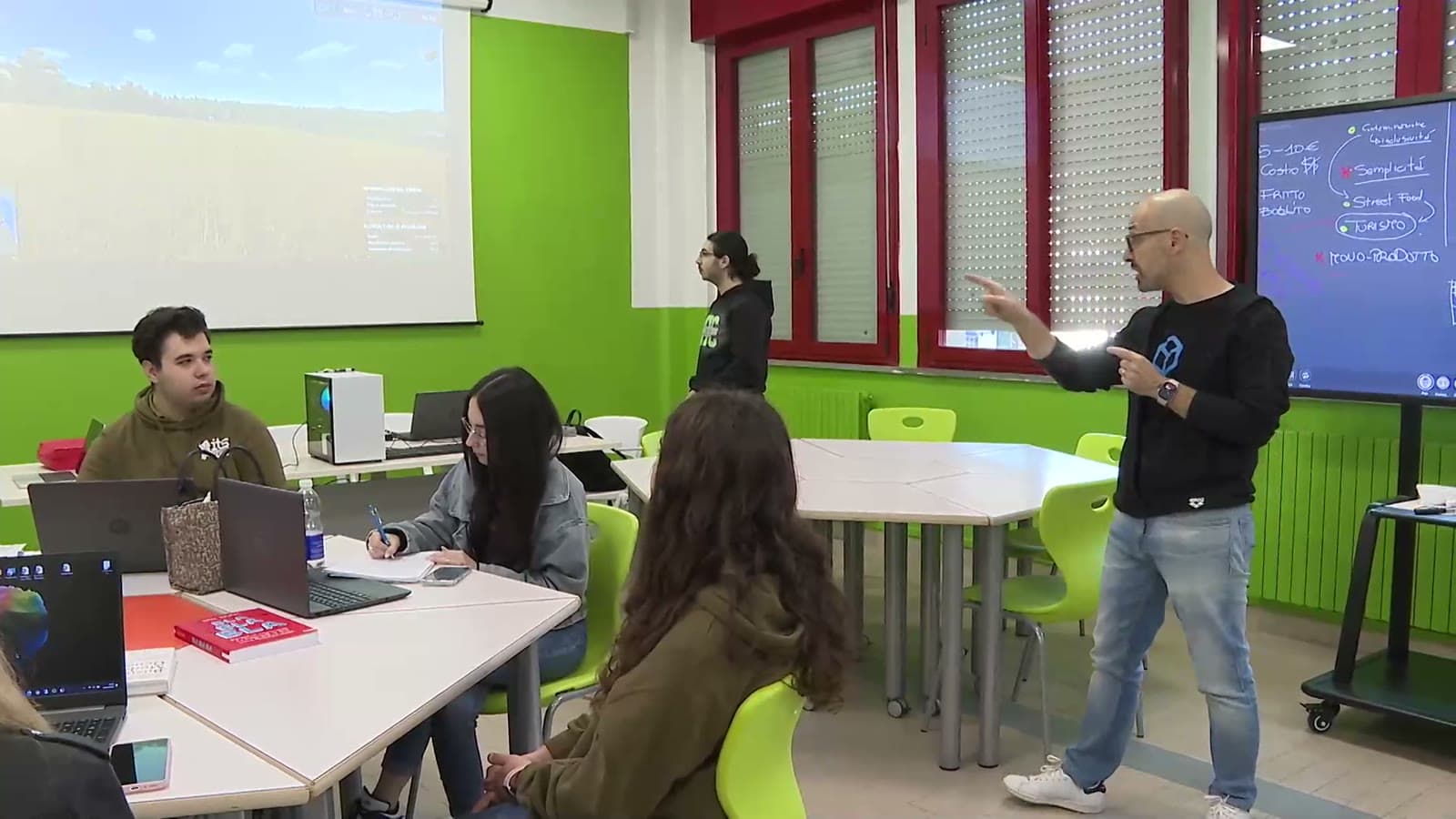 Facilitatore GameLab con un team davanti alla lavagna digitale durante una simulazione